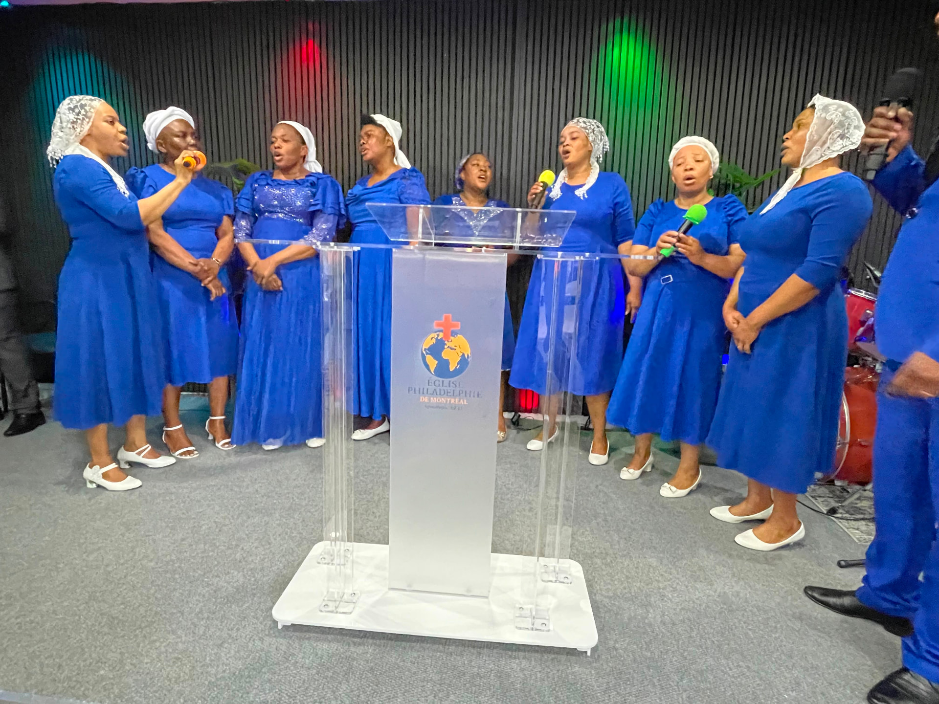 Les Dames EPM en robes bleues et voiles blancs chantant la louange derrière le pupitre de l'église